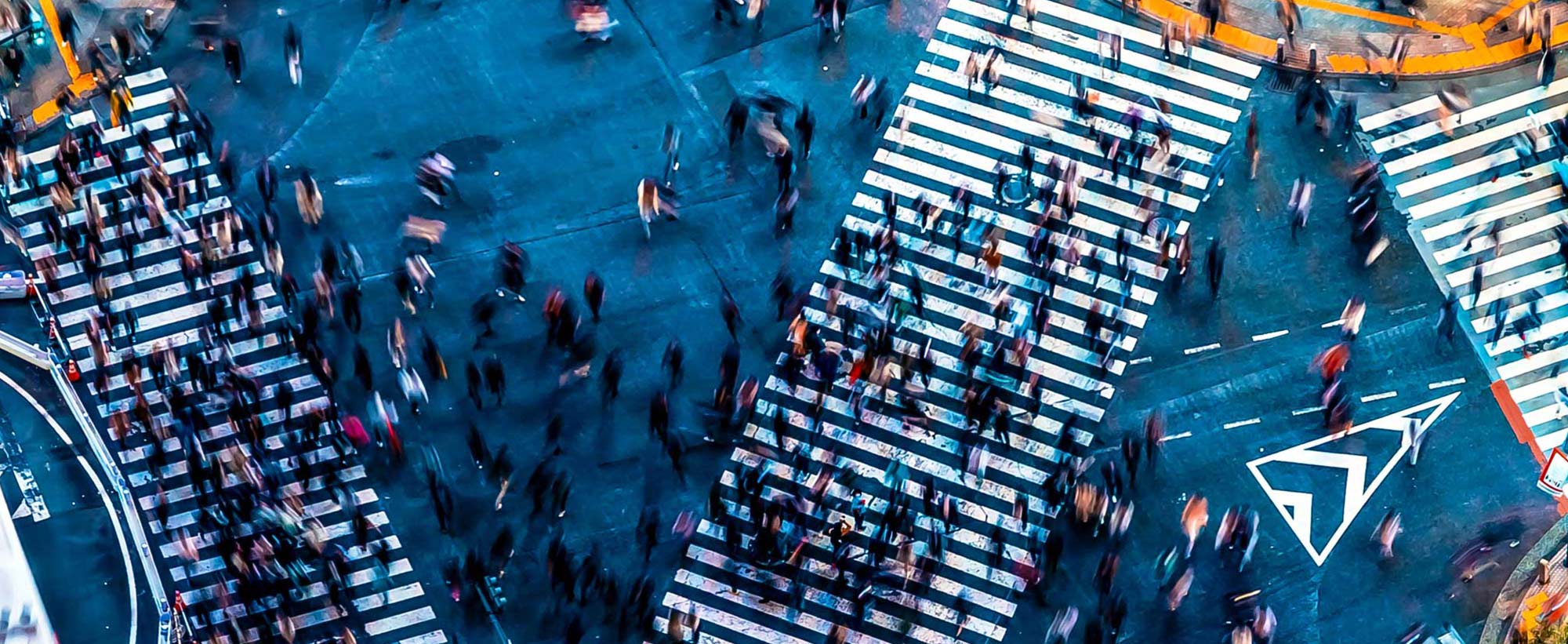 arial view of people crossing a busy intersection